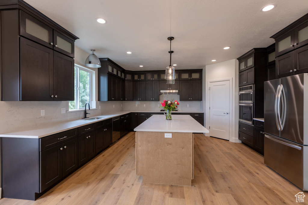 Kitchen with appliances with stainless steel finishes, a sink, a center island, tasteful backsplash, and recessed lighting