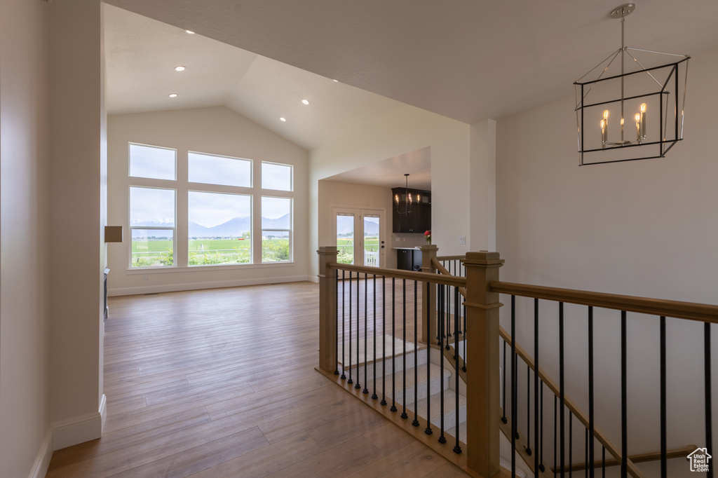 Corridor with a chandelier, an upstairs landing, plenty of natural light, recessed lighting, and high vaulted ceiling