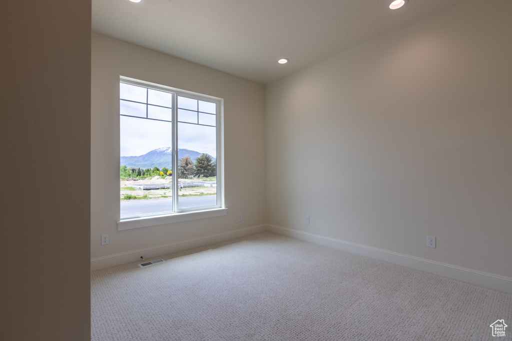 Carpeted empty room with a mountain view, baseboards, and recessed lighting