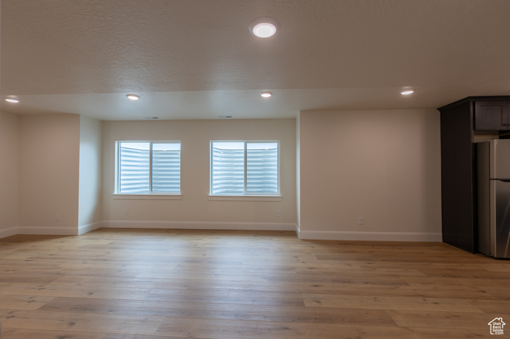 Empty room featuring baseboards, recessed lighting, and light wood-style floors