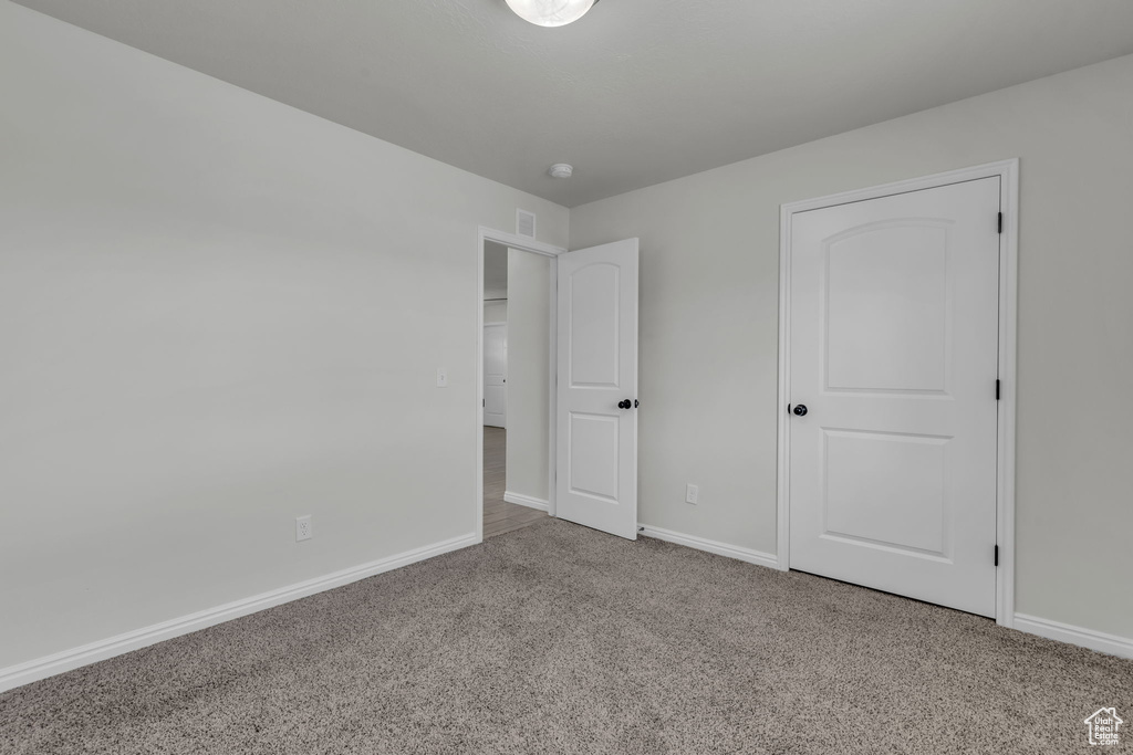 Unfurnished bedroom with light carpet