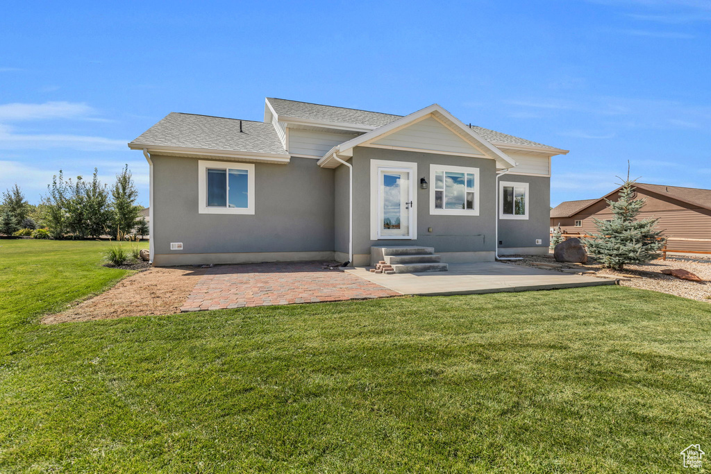 View of front of house with a patio and a front lawn