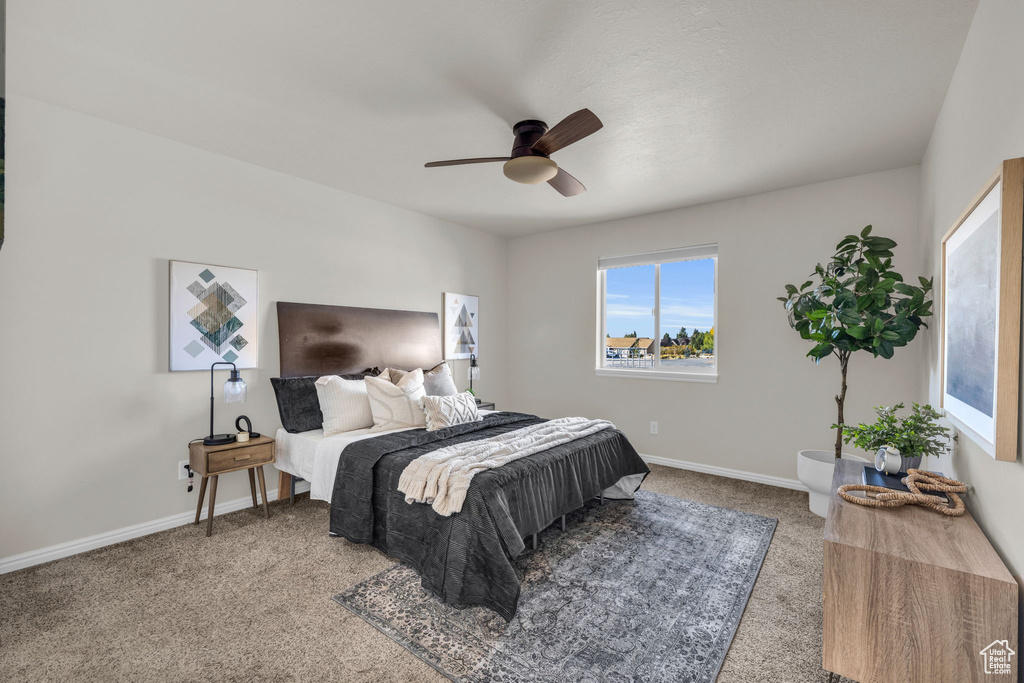 Carpeted bedroom featuring ceiling fan