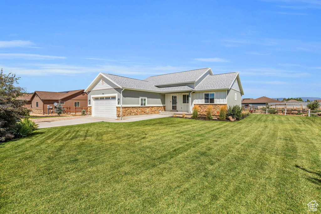 Ranch-style house with a garage and a front lawn