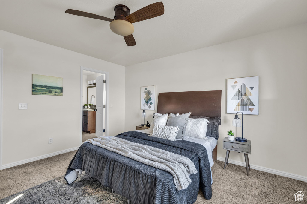 Bedroom with ensuite bath, ceiling fan, and light colored carpet