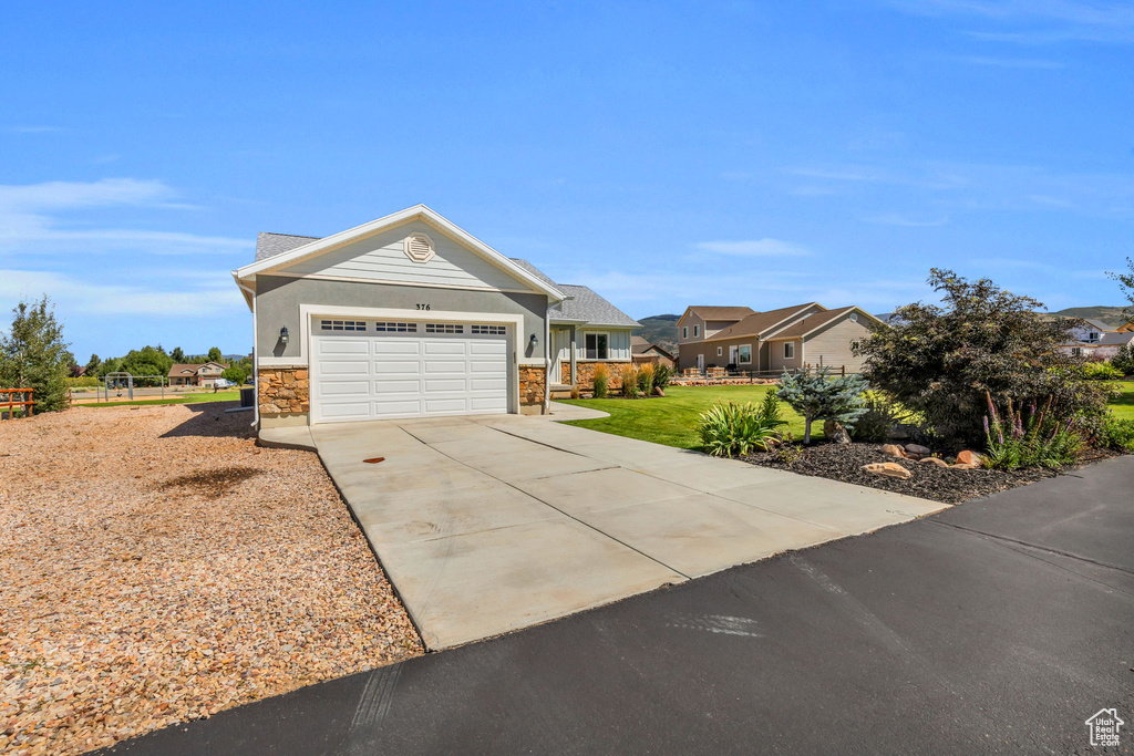 View of front of property featuring a garage and a front lawn