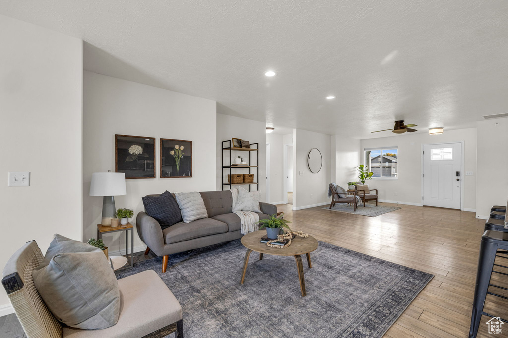 Living room with wood-type flooring and ceiling fan