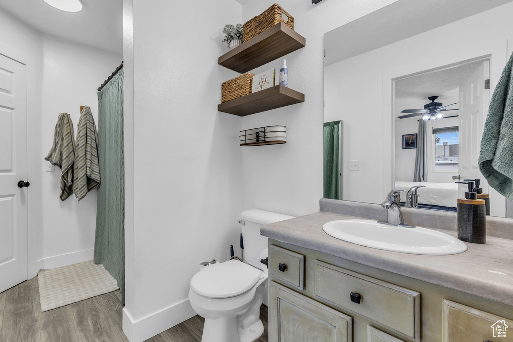 Bathroom featuring ceiling fan, toilet, hardwood / wood-style floors, and vanity