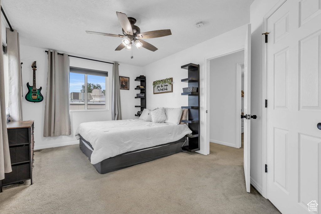 Bedroom with ceiling fan and light colored carpet