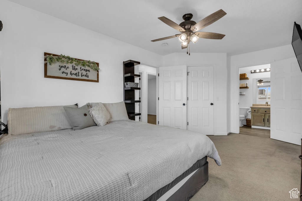 Carpeted bedroom with ceiling fan and ensuite bathroom