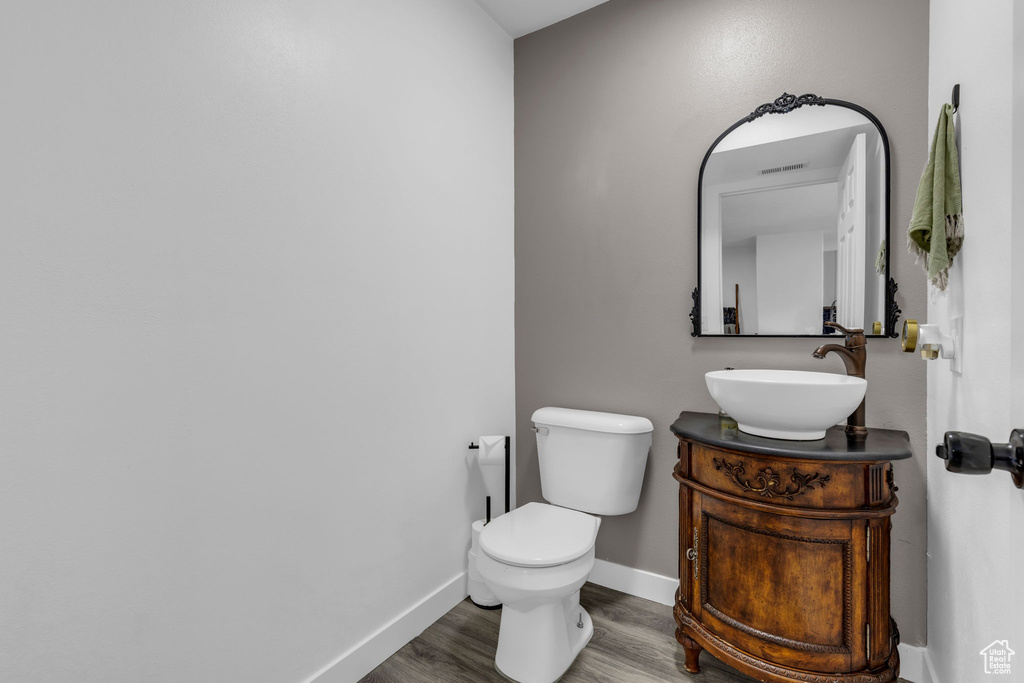 Bathroom featuring toilet, hardwood / wood-style flooring, and vanity