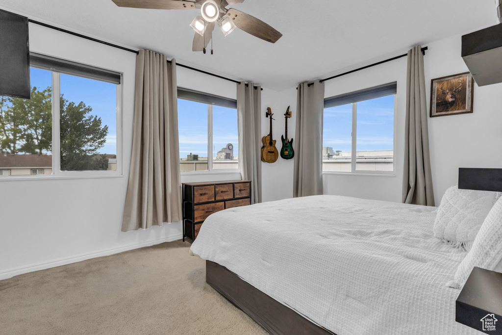 Carpeted bedroom featuring ceiling fan