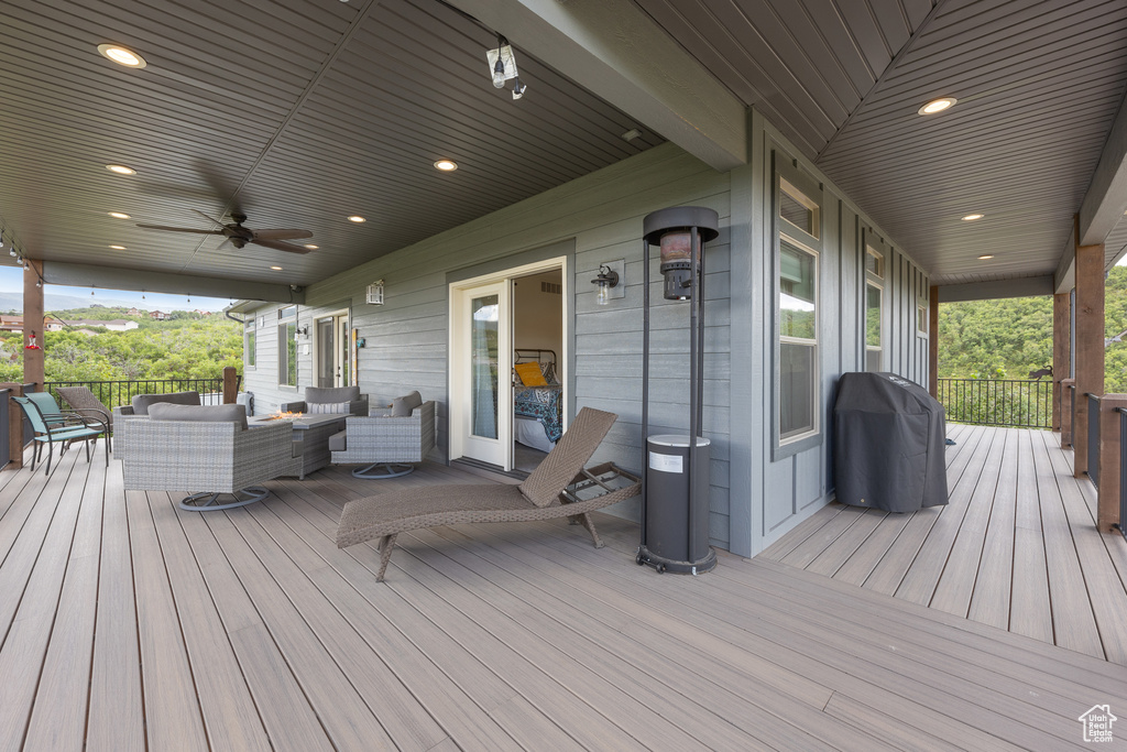 Wooden deck featuring ceiling fan and an outdoor hangout area