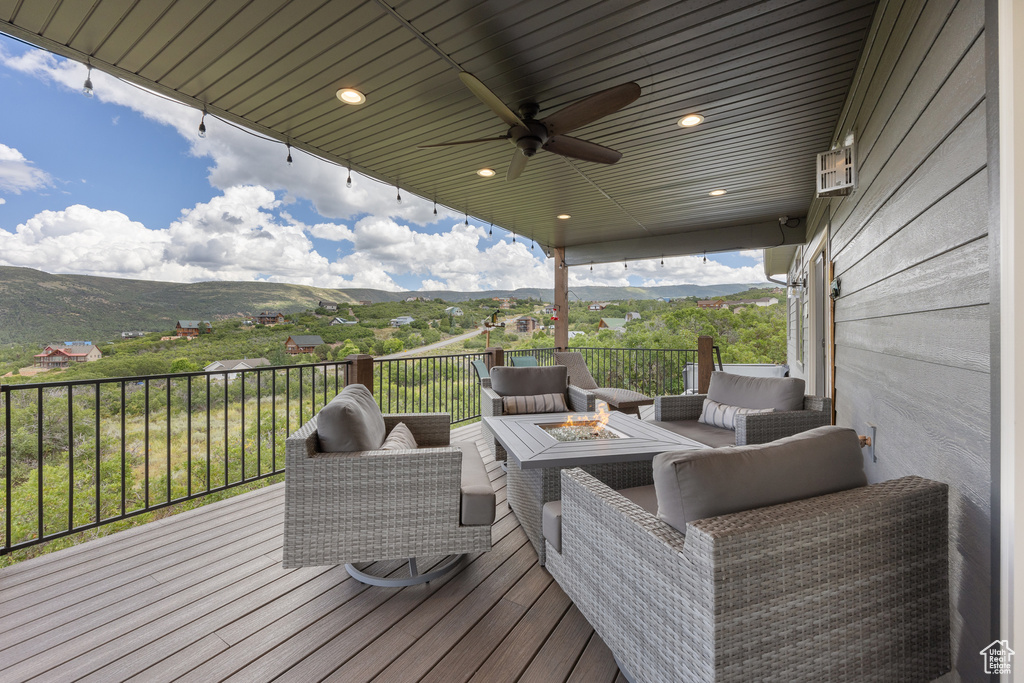 Wooden deck with ceiling fan, a mountain view, and an outdoor living space with a fire pit