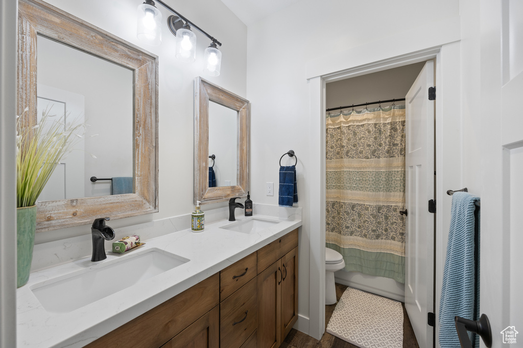 Bathroom with toilet and dual bowl vanity