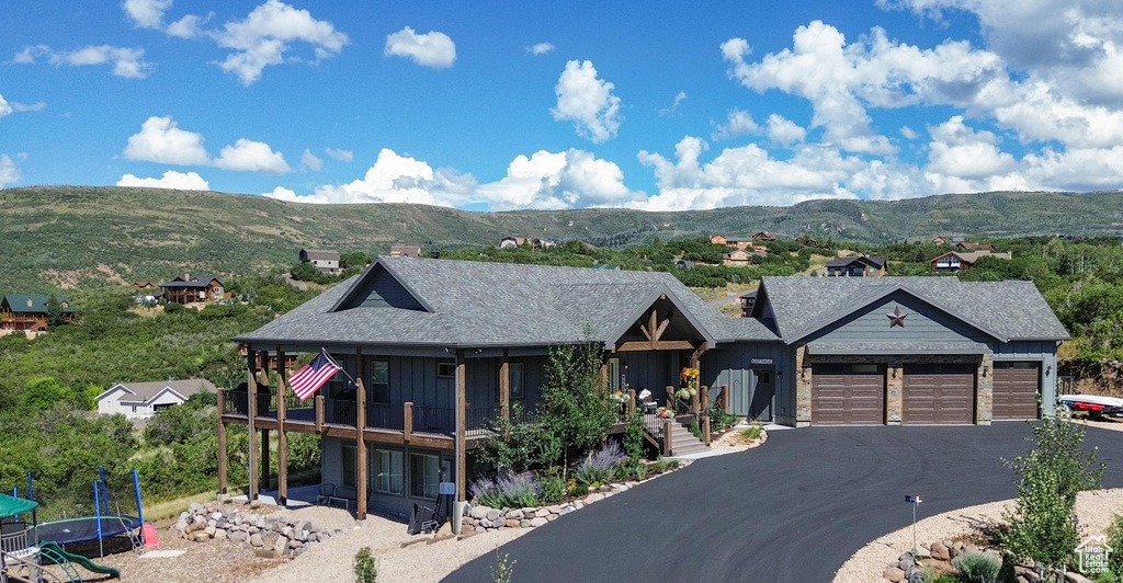 View of front of house featuring a trampoline, a garage, and a mountain view