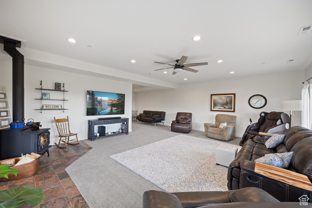 Tiled living room featuring ceiling fan and a wood stove