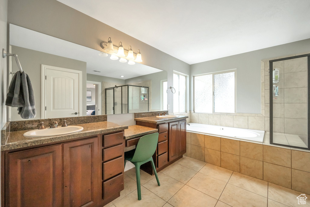 Bathroom featuring double vanity, shower with separate bathtub, and tile patterned floors