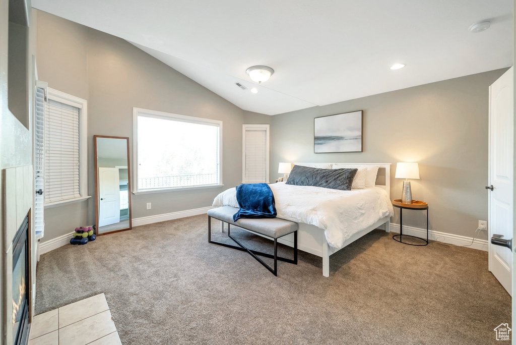 Bedroom with vaulted ceiling and light carpet