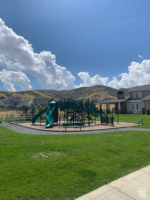 View of home's community featuring a lawn, a mountain view, and a playground