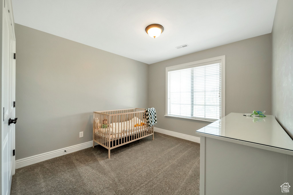 Carpeted bedroom with a crib