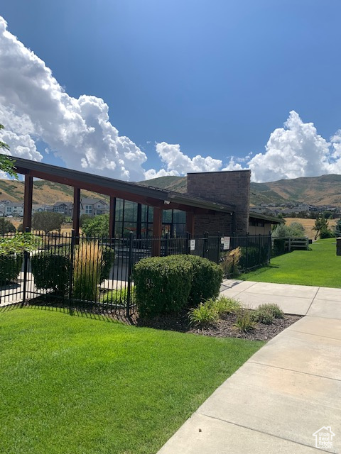 View of front of house featuring a mountain view and a front yard