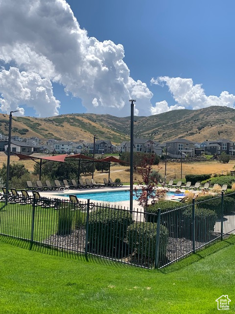 View of swimming pool with a mountain view and a lawn