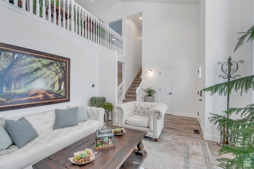 Living room featuring light hardwood / wood-style floors and a high ceiling