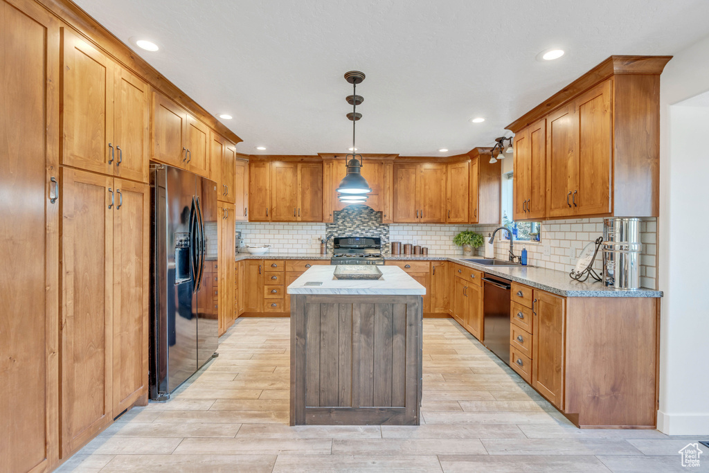 Kitchen featuring a kitchen island, decorative backsplash, stainless steel fridge with ice dispenser, and dishwasher