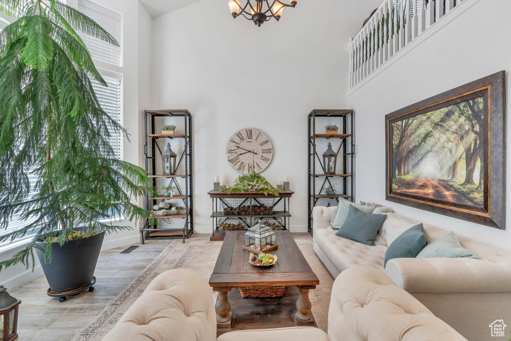 Living room featuring light wood-type flooring and a high ceiling