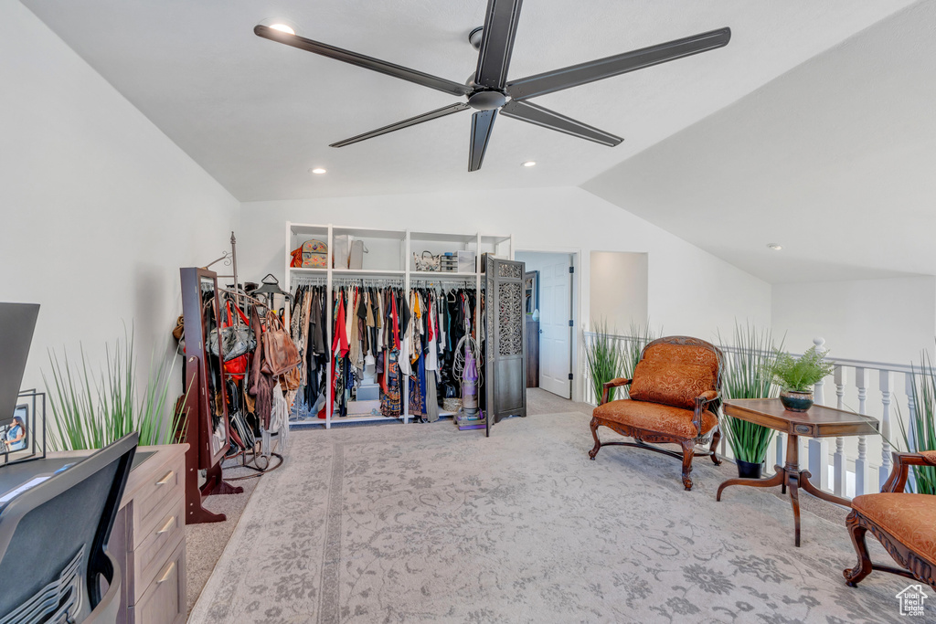 Sitting room with ceiling fan, light colored carpet, and lofted ceiling