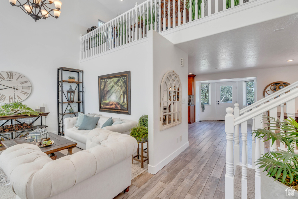 Living room featuring a high ceiling, hardwood / wood-style floors, and a chandelier