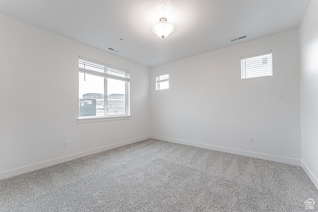 Unfurnished room with visible vents, baseboards, and carpet floors