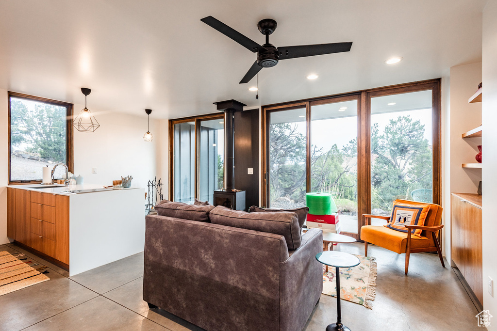 Living room with ceiling fan, sink, and expansive windows