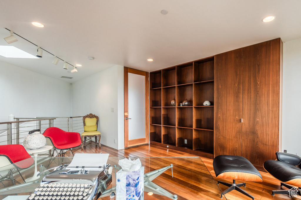 Sitting room featuring a skylight, rail lighting, and light hardwood / wood-style flooring