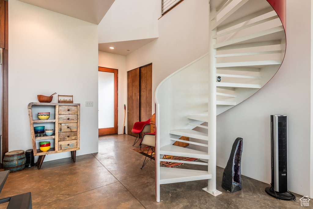 Stairway with a high ceiling and concrete flooring