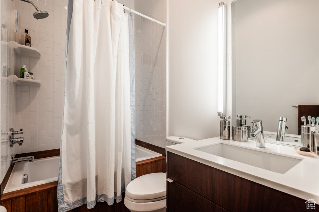 Full bathroom with shower / bath combination with curtain, toilet, and vanity