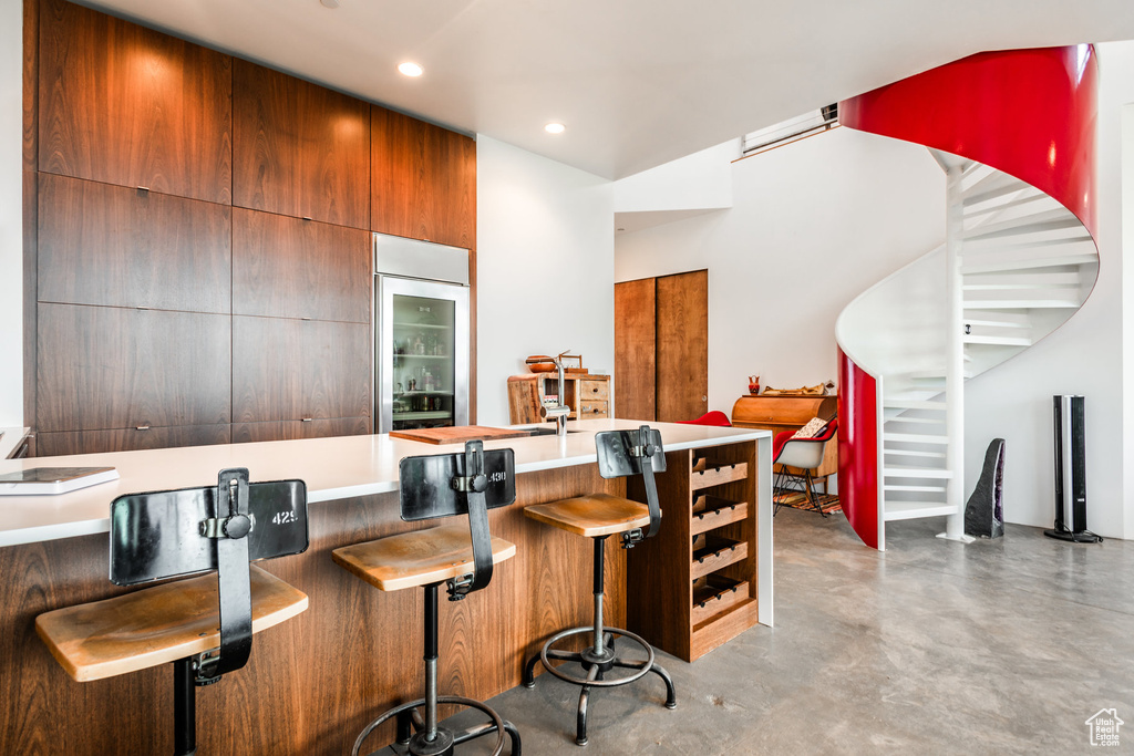 Kitchen with a breakfast bar area and concrete floors