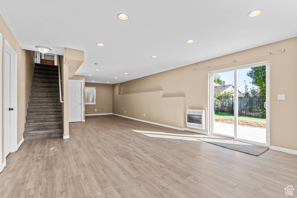 Unfurnished living room with light hardwood / wood-style floors and heating unit