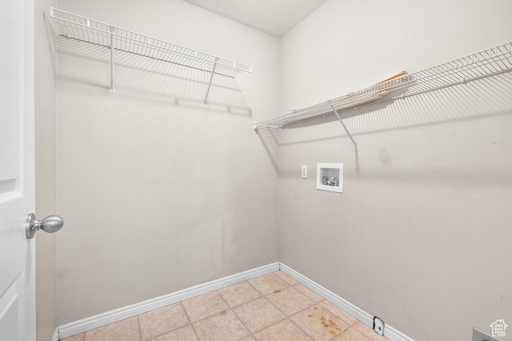 Laundry room with washer hookup and light tile patterned flooring