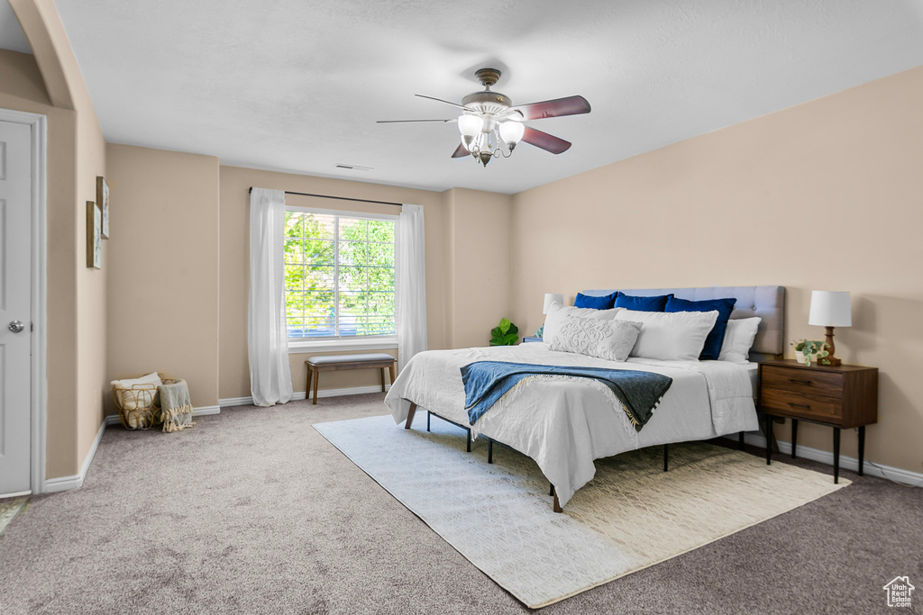 Bedroom with ceiling fan and light colored carpet