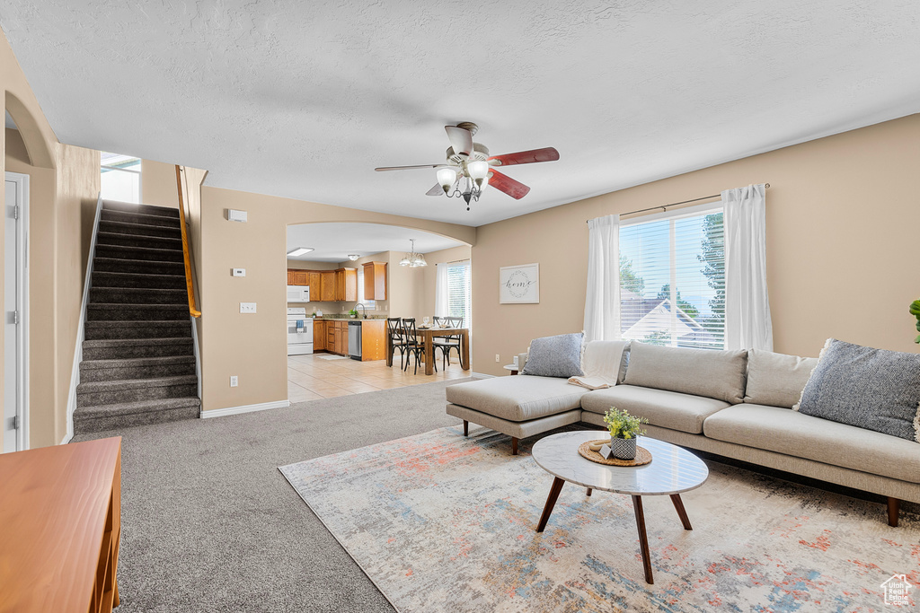 Tiled living room with ceiling fan and a textured ceiling