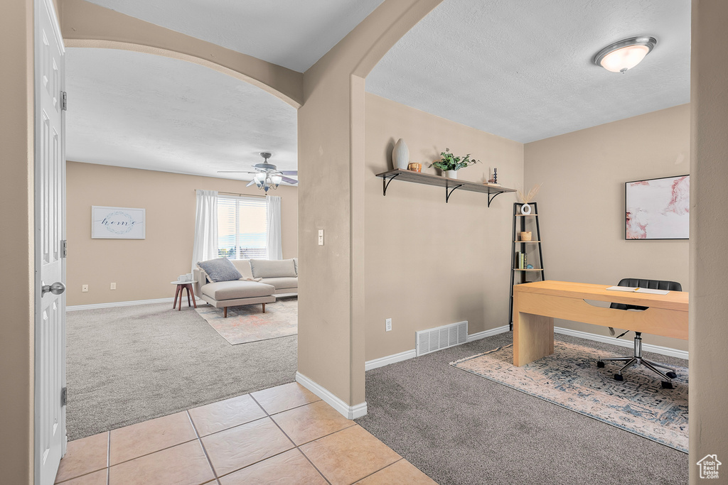 Carpeted office featuring ceiling fan