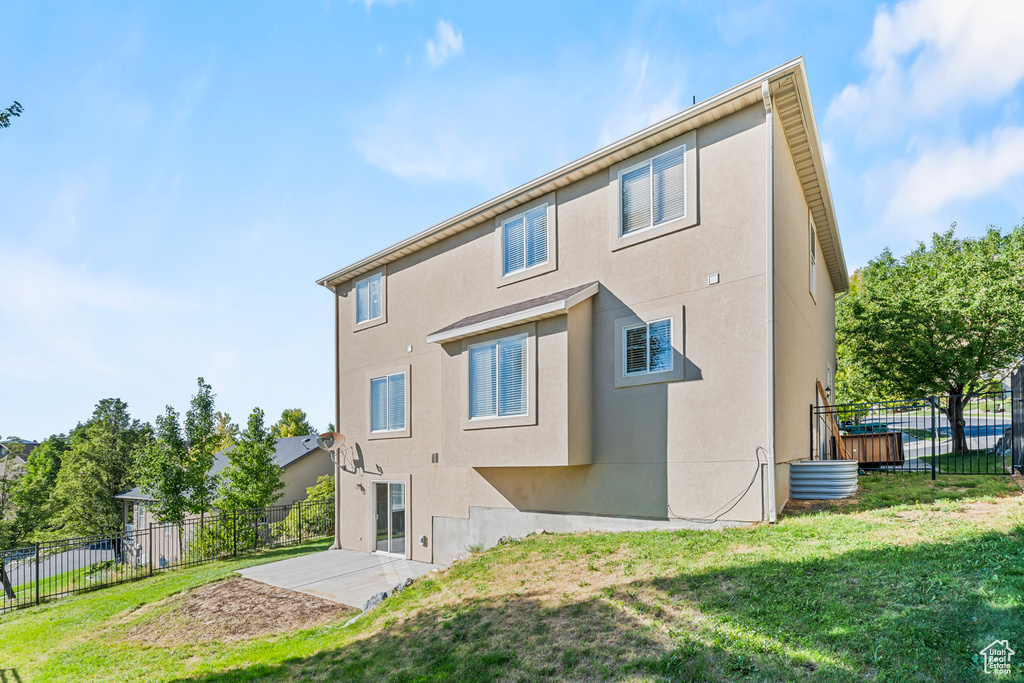 Rear view of property featuring a patio area and a lawn