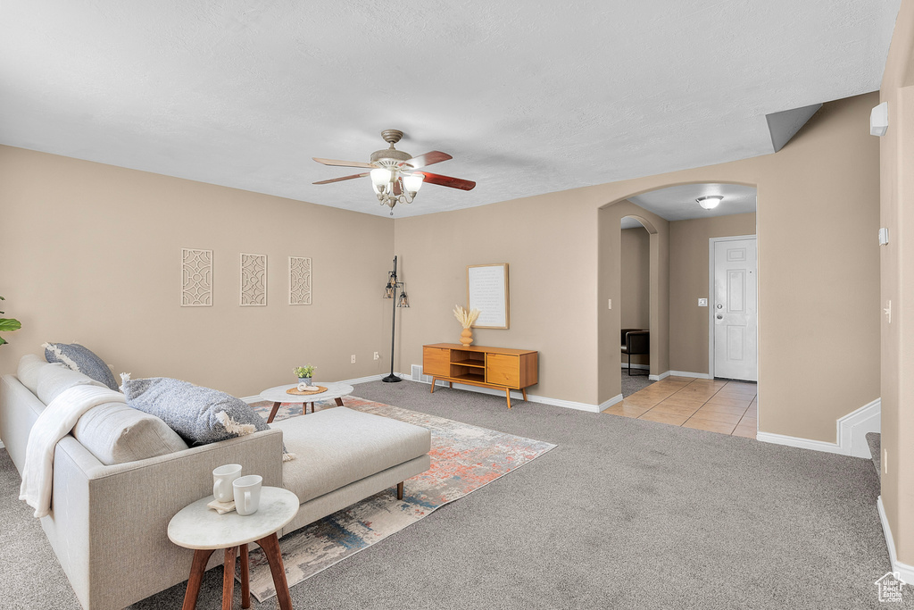 Living room with ceiling fan and light colored carpet