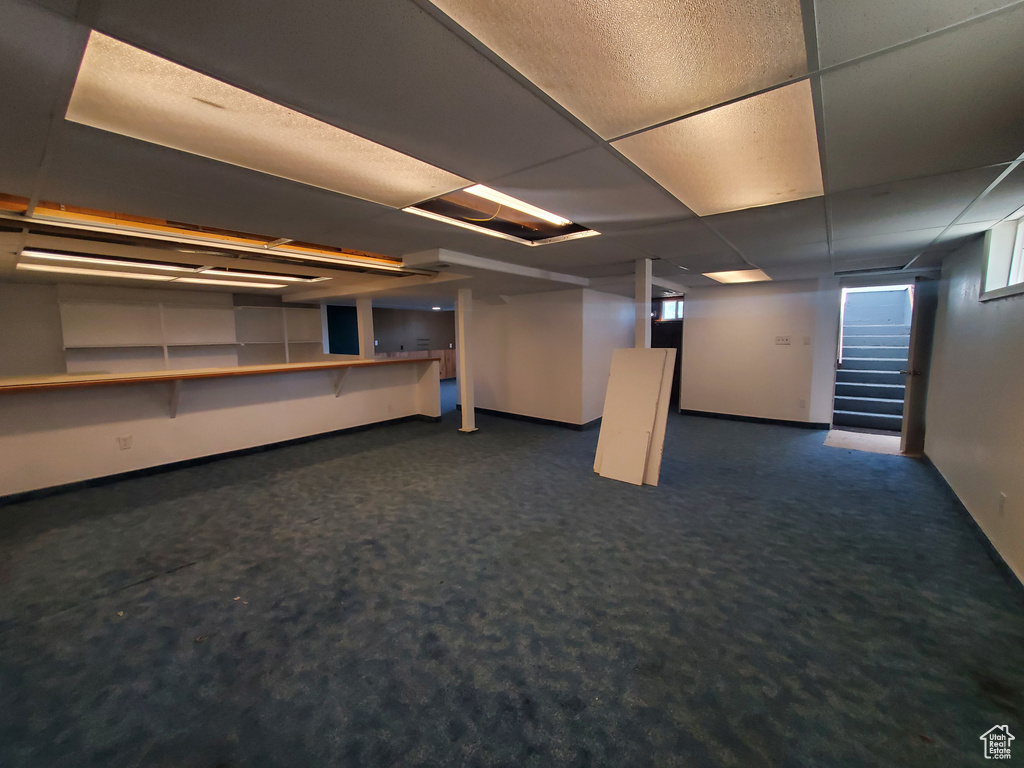 Basement with a drop ceiling and carpet flooring