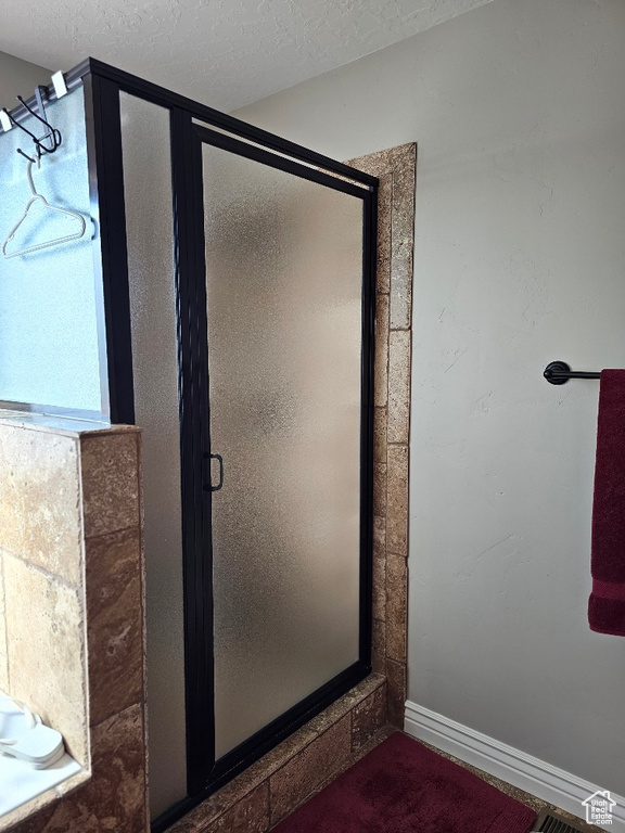 Bathroom with a textured ceiling and walk in shower