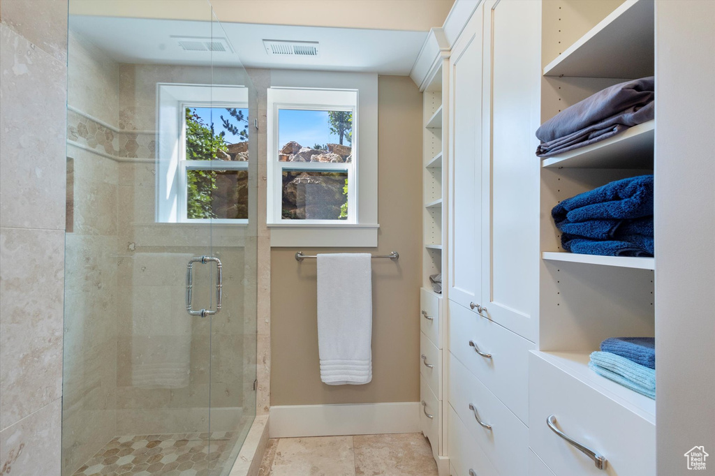 Bathroom featuring a shower with door and tile patterned floors