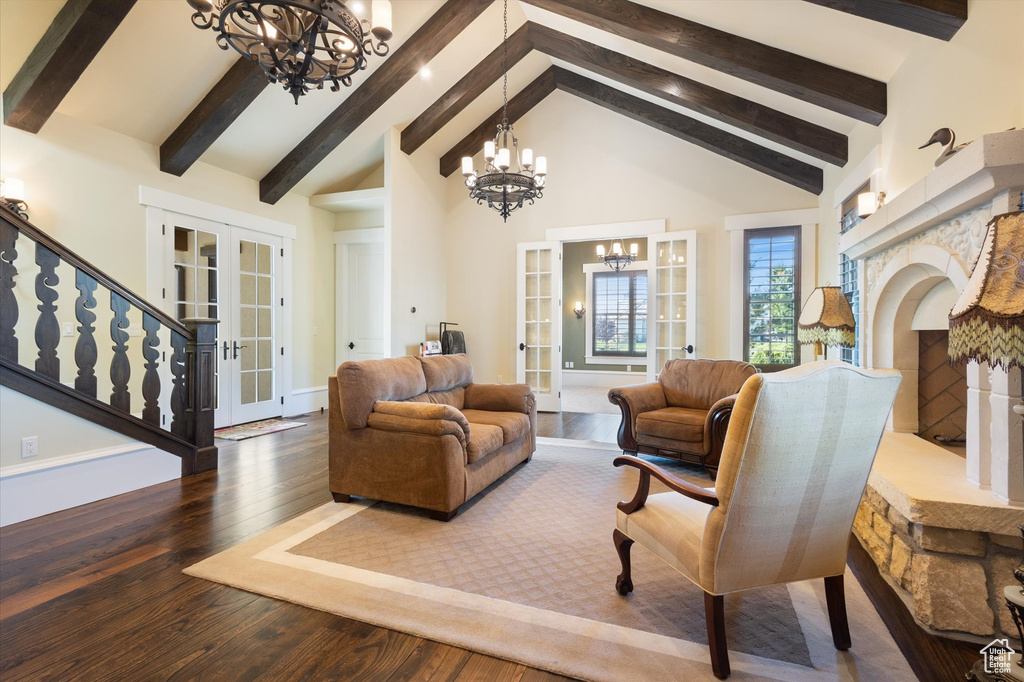 Living room with beamed ceiling, hardwood / wood-style flooring, an inviting chandelier, and french doors