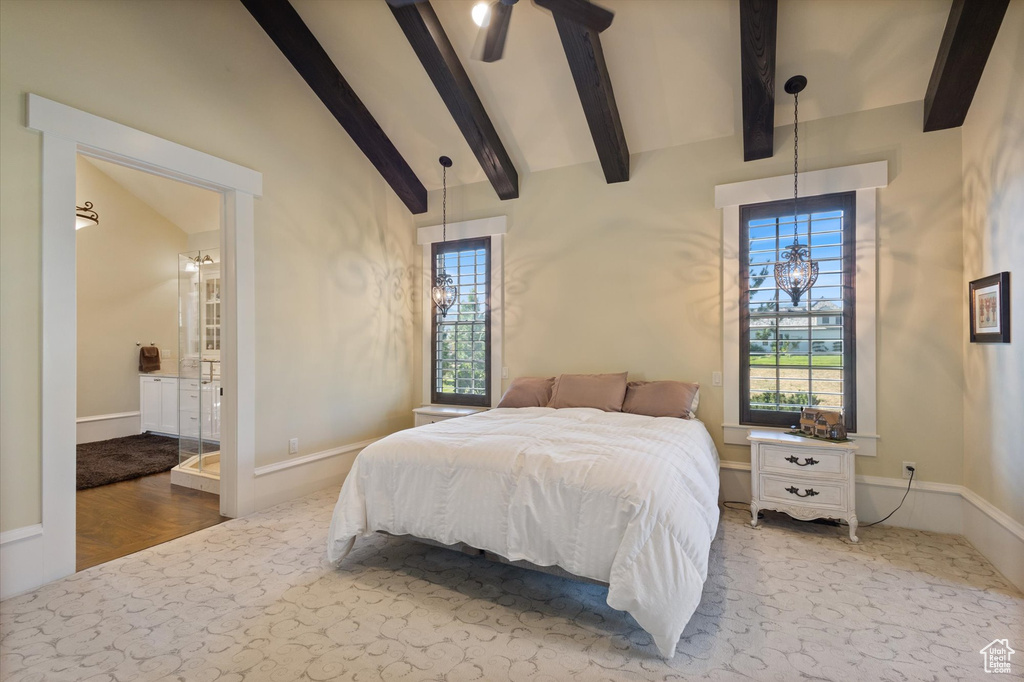 Bedroom with hardwood / wood-style floors, lofted ceiling with beams, and ensuite bath